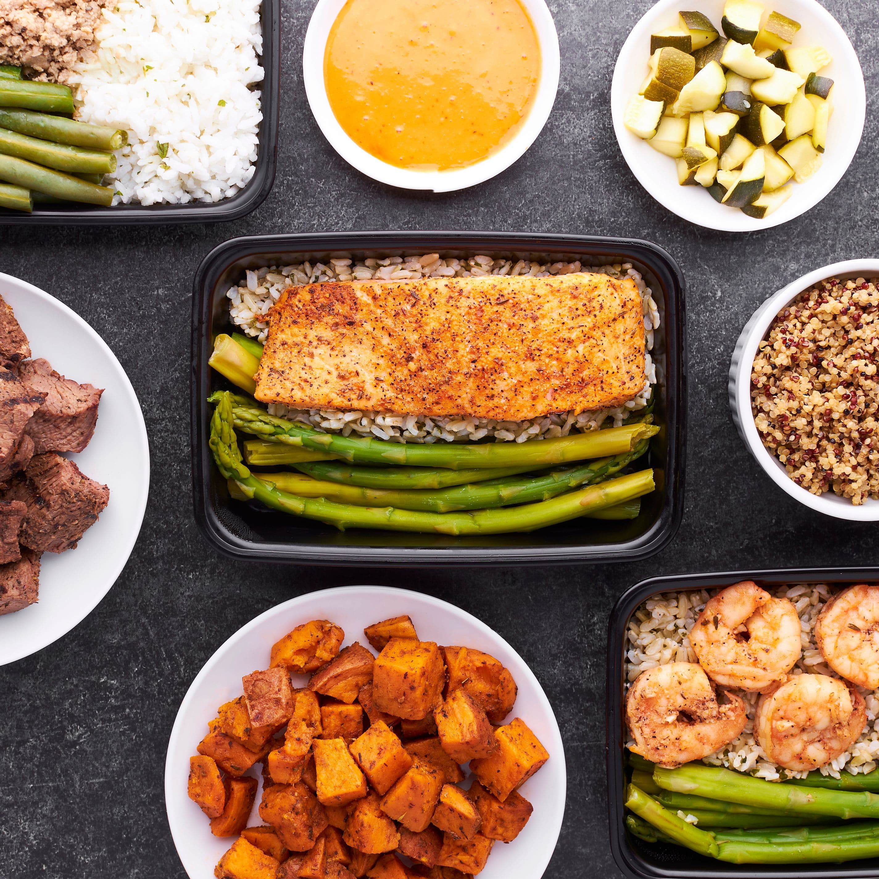 Prepared high-protein meal prep containers with salmon, rice, and vegetables